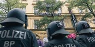Polizisten in schwerer Montur vor einem Albau in München