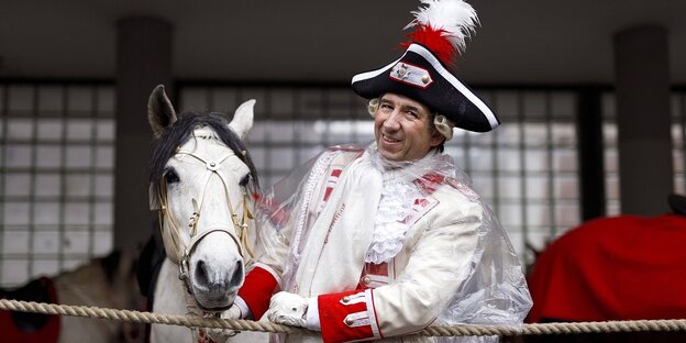 Ein mann in Karnevalsuniform und ein Pferd