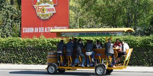 Eine Bier-Bike, auf dem etiche Männer sitzen, fährt vor dem Stadion des 1. FC Union Berlini vor