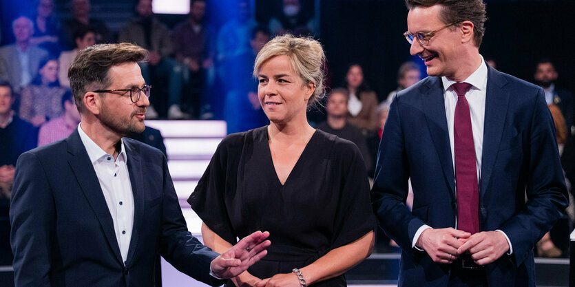 Eine Frau, umringt von 2 Männern im TV-Studio