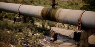 Ein Mann wäscht sich unter dem Leck einer Wasserleitung