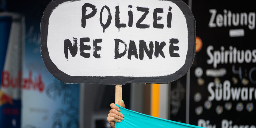 Ein Demonstrant hält das Schild Polizei nein Danke hoch