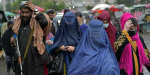 Frauen in Burka laufen auf einer Straße