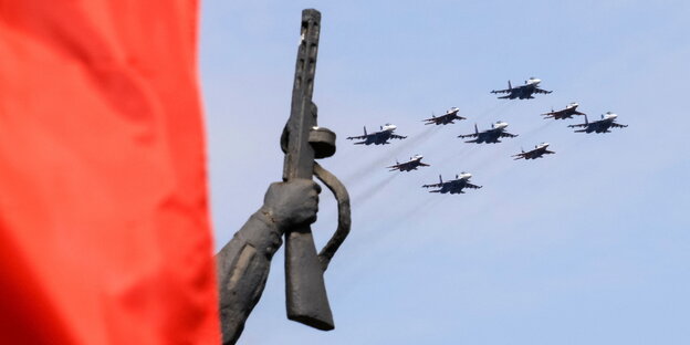 Russische MIG-29 fliegen in Formatiion über ein Monument in Moskau