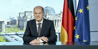 Olaf Scholz bei seiner TV-Ansprache neben einer Deutschland- und einer EU-Flagge