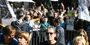 Hinter einer Absperrung rufen meist junge Demonstranten etwas