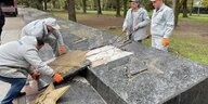 Arbeiter entfernen goldenen Stern aus Gedenkstein