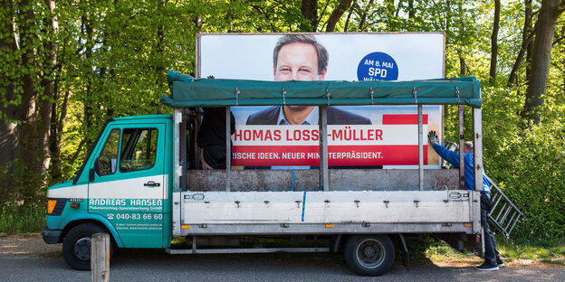 Auf einem Laster wird ein Wahlplakat von Losse-Müller abtransportiert