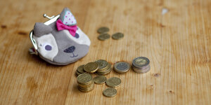 euromünzen und ein Kinderportemonnaie mit Pandagesicht und Schleife