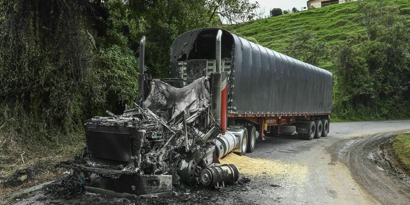 Ein ausgebrannter Lastwagen steht auf einer Landstraße