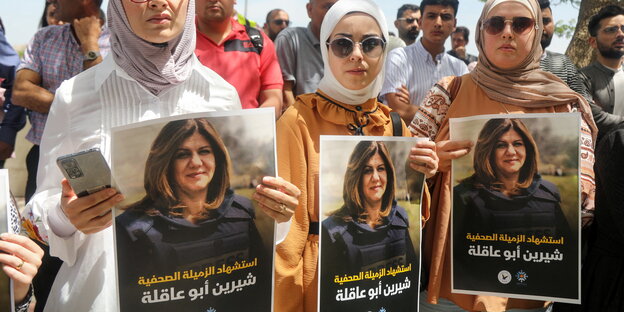 Drei Frauen halten Plakat mit dem Bilder der getöteten Journalistin hoch