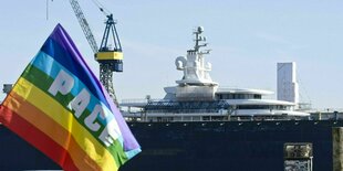 Eine Peace-Flagge vor einer Megayacht in Hamburg am Hafen