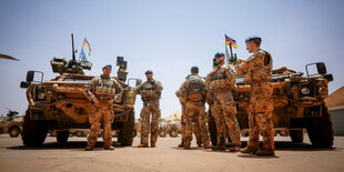 Bundeswehrsoldaten stehen vor 2 Panzern mit deutscher Flagge