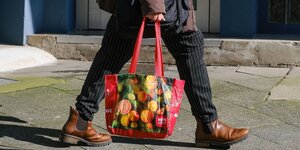 Eine Frau trägt eine bunte Einkaufstasche, Detailaufnahme