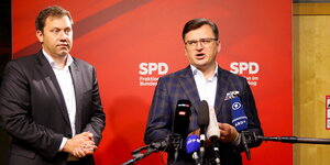 Vor einer Wand der SPD stehen zwei Männer in Anzügen, einer von ihnen spricht.