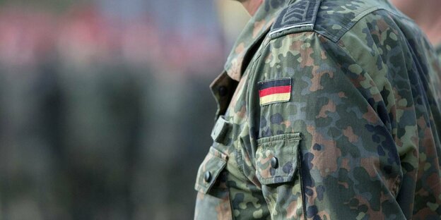 Soldat mit Feldbluse in Flecktarn mit dem Hoheitszeichen der Bundesrepublik Deutschland