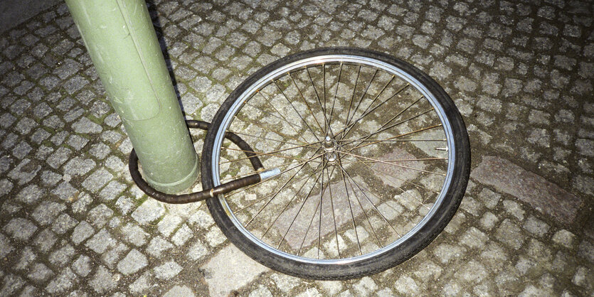 Einsames Fahrrad-Rad an Laternenpfahl