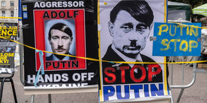 Plakate, auf denen Putin mit Hitlerschnurrbart zu sehen ist