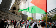Ein Mann schwingt eine palästinensische FahnePro