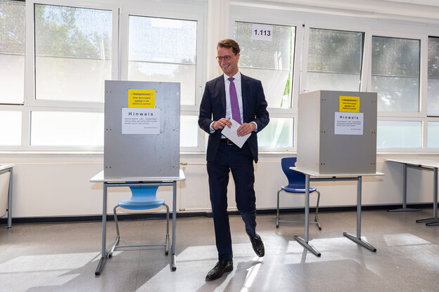 Hendrik Wüst (CDU), Ministerpräsident des Landes Nordrhein-Westfalen, steht im Wahllokal und gibt seinen Stimmzettel ab.