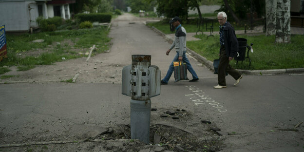 Einwohner passieren eine feststeckende Rakete bei Luhansk