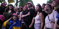 Fröhliche Menschen, die alle die gleichen pinkfarbigen Hüte tragen