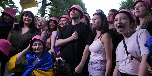 Menge in der alle rosa farbene Hüte tragen