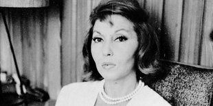 Die brasilianische Schriftstellerin Clarice Lispector sitzt auf einem Stuhl und blickt in die Kamera