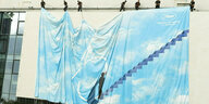 Riesenposter mit blauen Himmel und ein Mann geht eine Treppe hoch, die Zahl 75 steht für das Jubiläum in Cannes