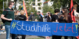 Studierende mit einem Banner auf dem steht "Studihilfe jetzt!"