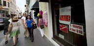 Menschen laufen eine Einkaufsstraße in San Juan entlang