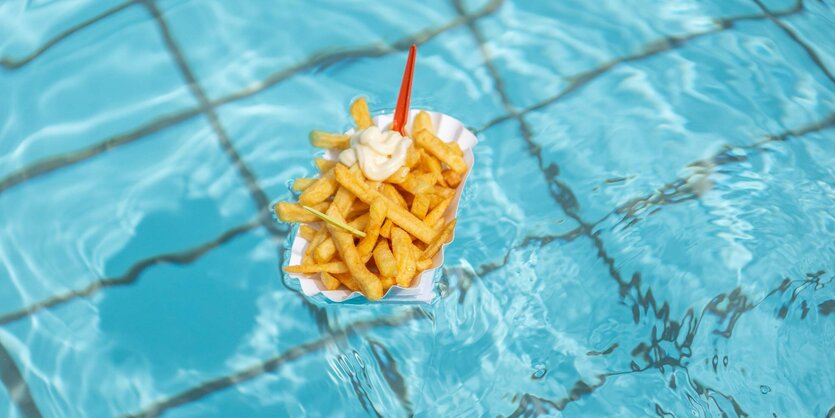 Eine Portion Pommes Frtes schwimmt im Pool