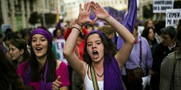 Frauen protestieren mit lila Schals