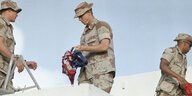 Eine zerknüllte USA Fahne wird von einem Soldaten gehalten