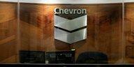 An einer holzvertäfelten Wand hängt das Chevron-Logo