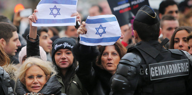 In einer Menschenmenge werden vereinzelt israelische Flaggen hochgehalten.