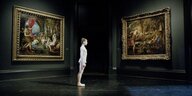 Eine Ballerina steht zwischen zwei Gemälden in der National Gallery