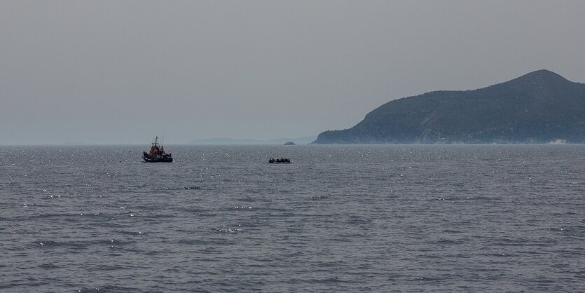 Blick auf das Meer, man sieht ein Schiff der griechischen Küstenwache und ein Flüchtlingsboot in der ferne