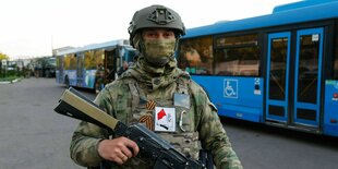 Ein russischer Soldat bewacht die Busse, mit denen die gefangenen Ukrainer weggebracht werden