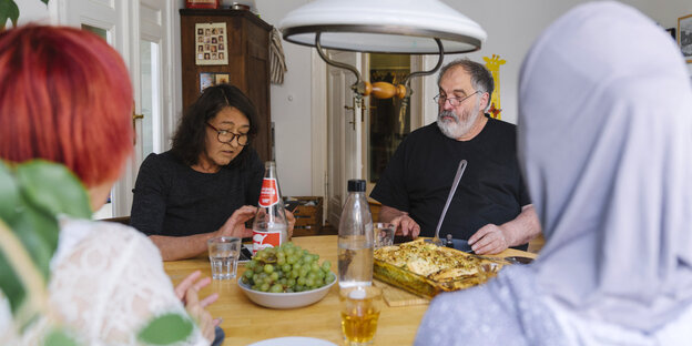 Geflüchtete Menschen beim gemeinsamen Essen an einem Tisch