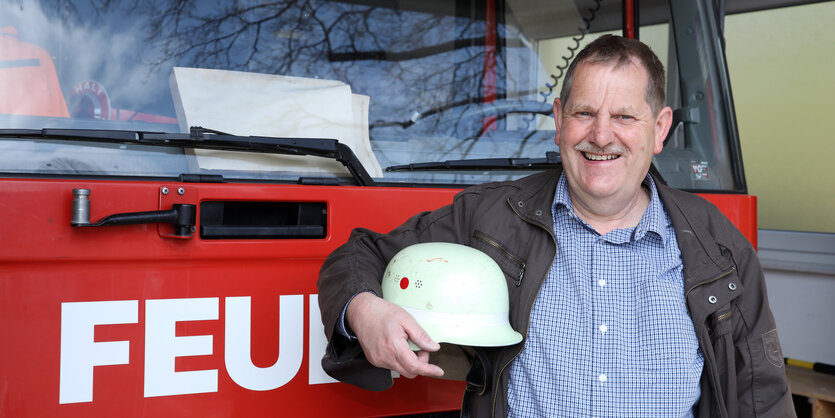 Albert Mausehund vor einem Feuerwehrauto