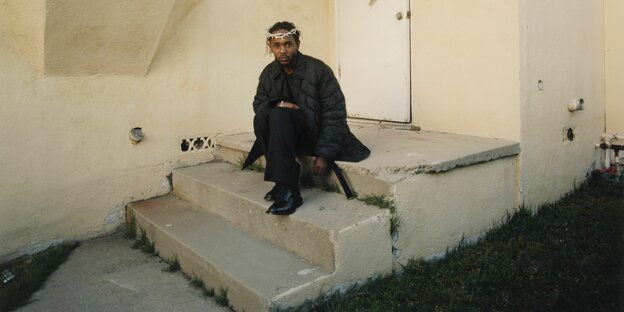 Kendrick Lamar sitzt mit Dornenkrone auf den Treppen eines Hauses in Los Angeles