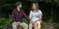 Episodenbild: Mann und Frau sitzen Händchenhaltend auf einem Baumstamm
