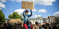 Bei einer BLM Demo in berlin hält ein Kind ein Plakat hoch