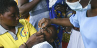 Eine Mutter hält ein Kind, das eine Impfung bekommt