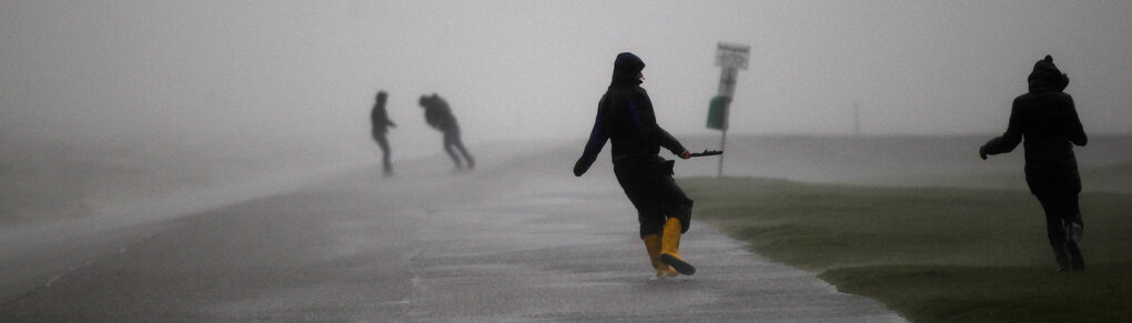 Menschen laufen im Regen und Sturm