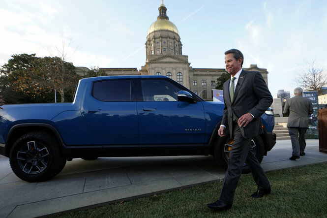 Ein Mann vor einem blauen Truck, einem Rivian electric truck, in Atlanta