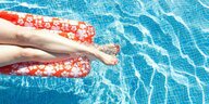 Frau auf einer Luftmatratze in einem Pool