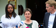 Zwei Frauen und ein Mann stehen nebeneinander, ein Reporter hält der Frau in der Mitte ein Mikrofon hin