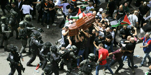 Palästinenser tragen einen Sarg und werden umzingelt